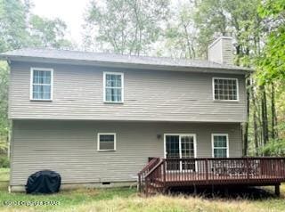 rear view of house with a chimney and a deck