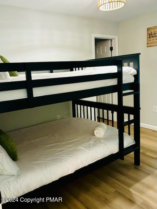 bedroom featuring baseboards and wood finished floors