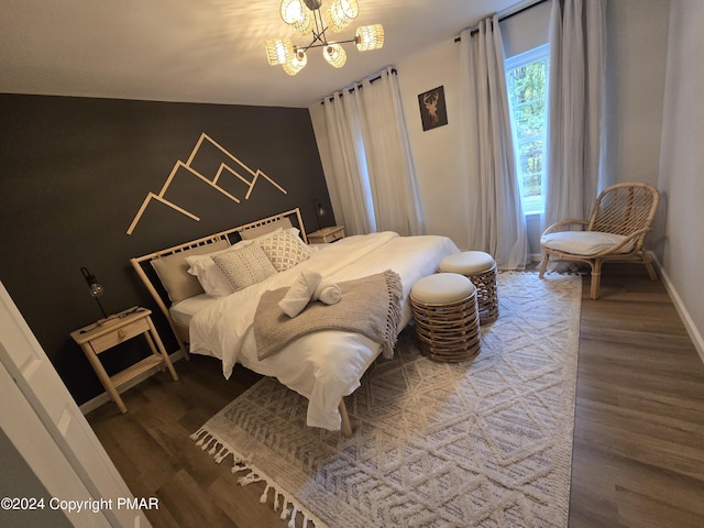 bedroom featuring baseboards, a chandelier, and wood finished floors