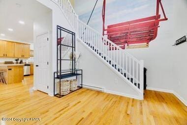 stairway featuring recessed lighting, wood finished floors, and baseboards