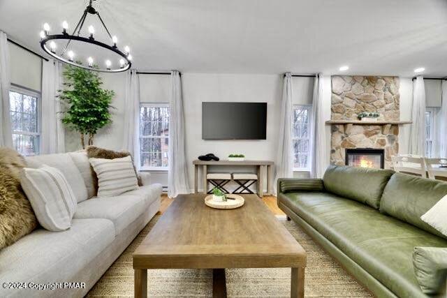 living area featuring a stone fireplace and wood finished floors