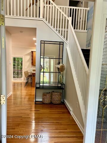 stairs featuring baseboards, a high ceiling, and wood finished floors