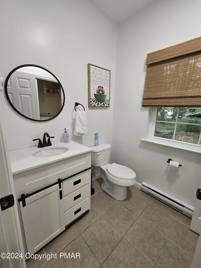 bathroom featuring tile patterned flooring, toilet, vanity, baseboards, and baseboard heating