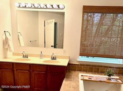 full bathroom with double vanity, a sink, and tile patterned floors