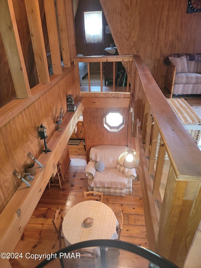 interior space with hardwood / wood-style floors and wood walls