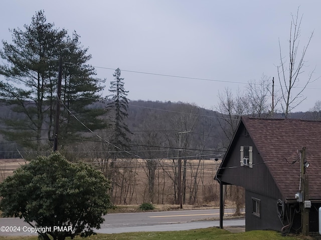view of side of home with a shingled roof