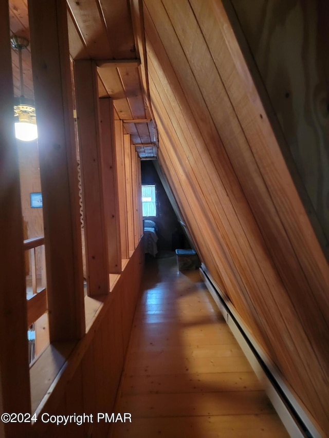 hallway featuring lofted ceiling, a baseboard radiator, and hardwood / wood-style flooring