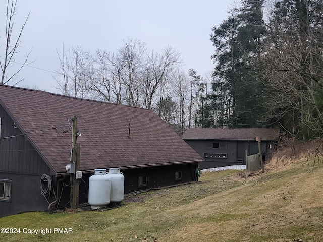 view of home's exterior with a yard and roof with shingles