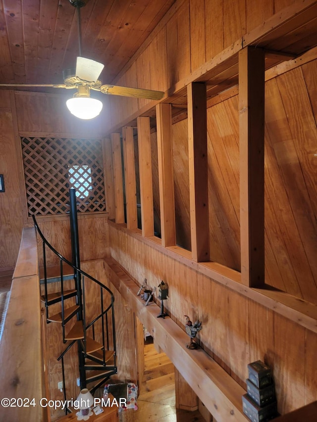 stairs with wooden ceiling, wood walls, and wood finished floors