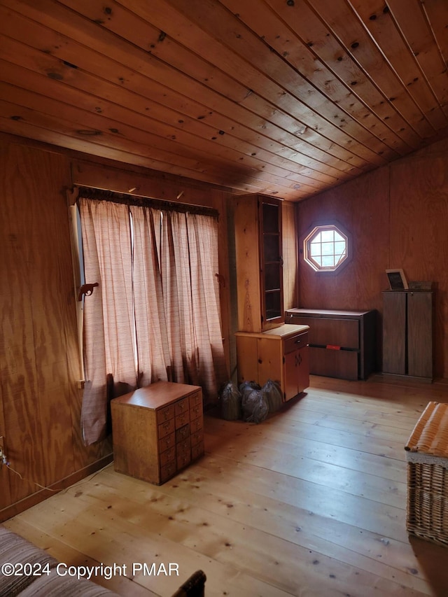 interior space with wood walls, light wood-style floors, and wooden ceiling