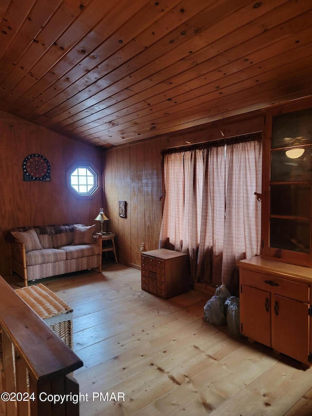 living area with light wood-type flooring, wood walls, and wood ceiling