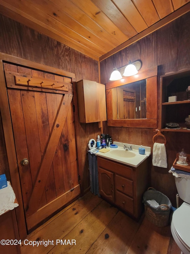 bathroom featuring wood walls, toilet, vanity, wood ceiling, and wood-type flooring
