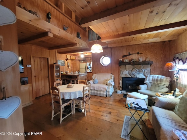 living area with wooden walls, hardwood / wood-style flooring, a fireplace, beam ceiling, and wooden ceiling