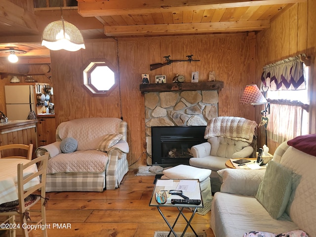 living room with hardwood / wood-style floors, wood walls, wooden ceiling, and beam ceiling