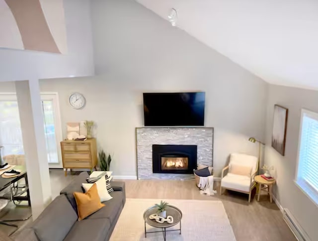 7126 Robinwood Dr, Tobyhanna, PA 18466 - living room with a baseboard heating unit, wood finished floors, lofted ceiling, and a fireplace