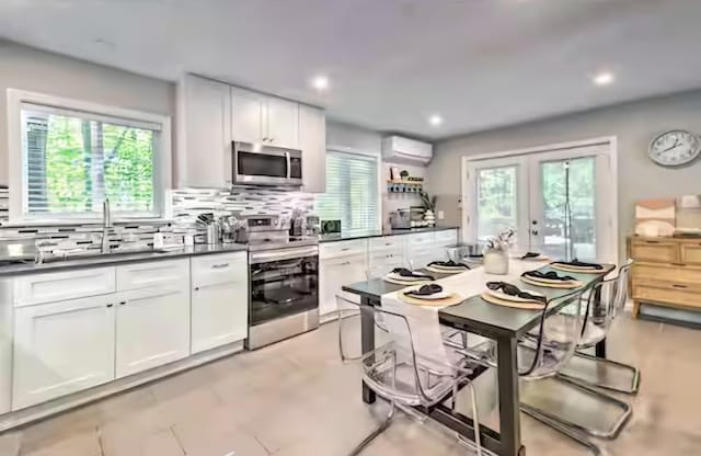 7126 Robinwood Dr, Tobyhanna, PA 18466 - kitchen with a wall mounted air conditioner, dark countertops, backsplash, and stainless steel appliances