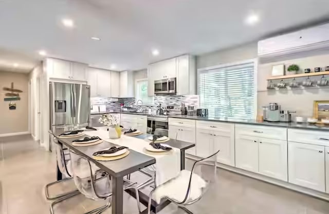 7126 Robinwood Dr, Tobyhanna, PA 18466 - kitchen with recessed lighting, stainless steel appliances, decorative backsplash, a kitchen breakfast bar, and dark countertops