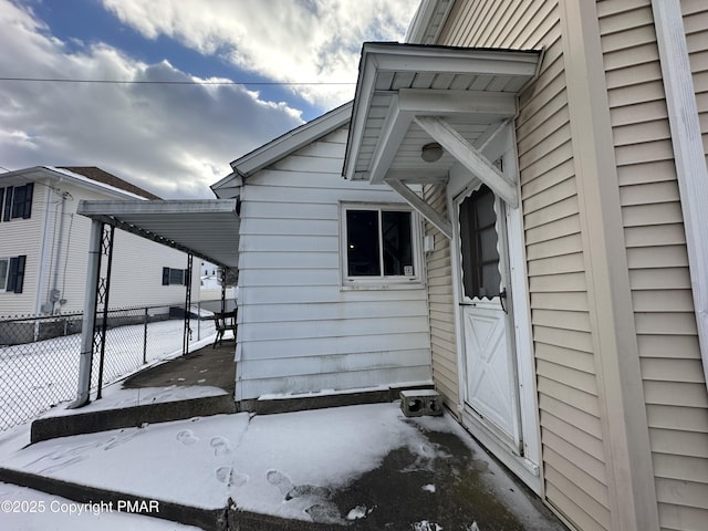 snow covered property entrance featuring fence