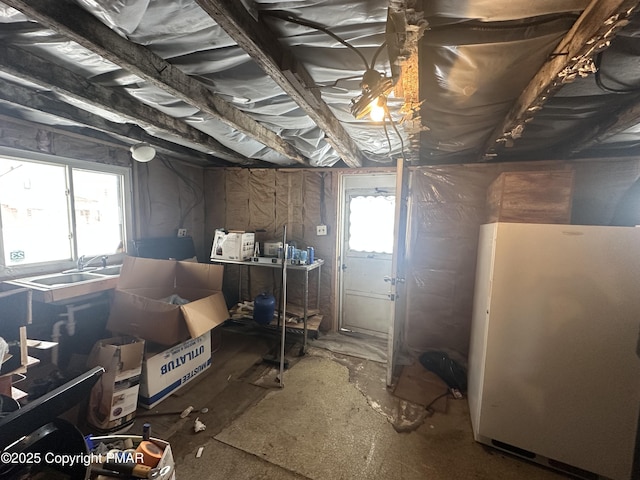 basement featuring freestanding refrigerator and a sink