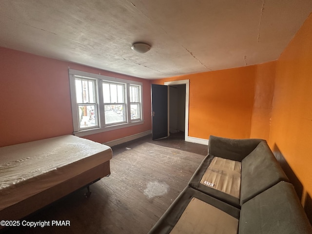 bedroom with baseboards and wood finished floors