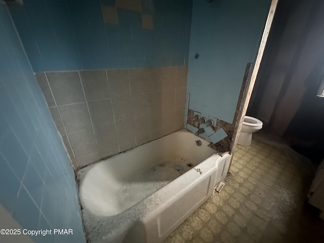 bathroom featuring tile patterned floors, toilet, and a bathtub