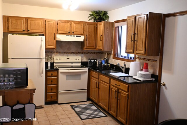 101 Withywindle Way, Tamiment, PA 18371 - kitchen featuring white appliances, under cabinet range hood, dark countertops, decorative backsplash, and light tile patterned floors