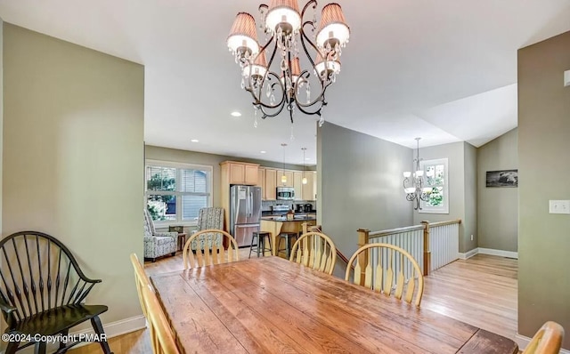 dining room with plenty of natural light, a notable chandelier, and light wood-style flooring