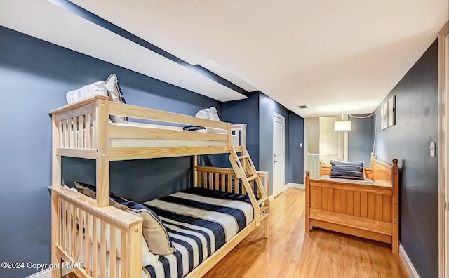 bedroom with visible vents, baseboards, and wood finished floors