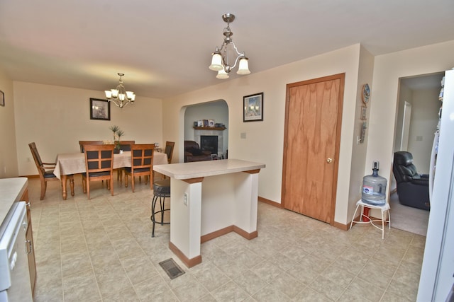 kitchen featuring a kitchen breakfast bar, a notable chandelier, visible vents, light countertops, and hanging light fixtures