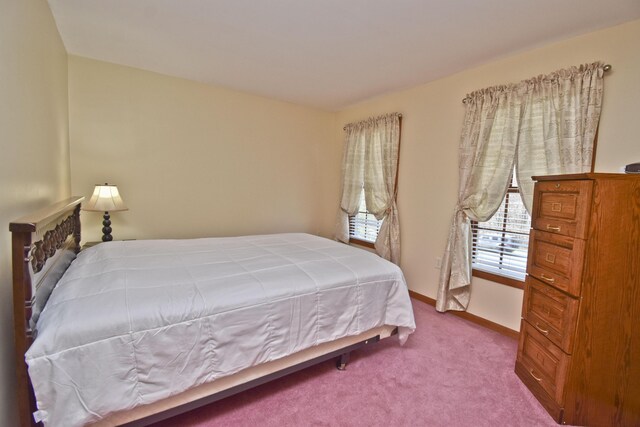 carpeted bedroom featuring baseboards