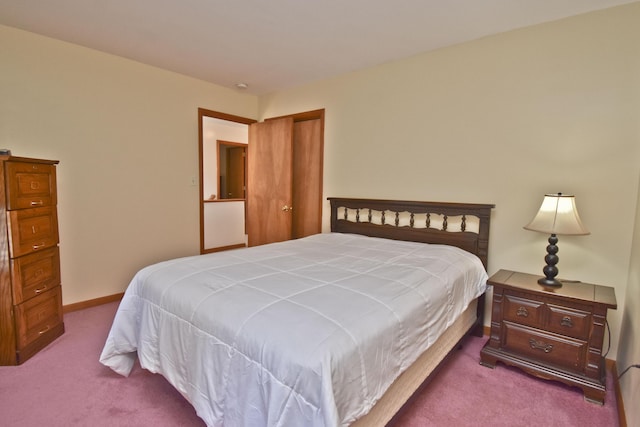 carpeted bedroom featuring baseboards and a closet