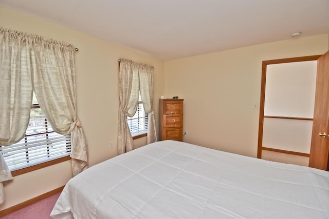 carpeted bedroom with baseboards and multiple windows