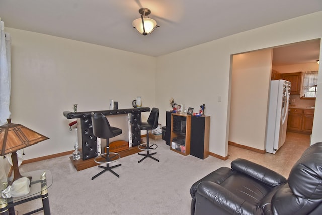 office space with baseboards and light colored carpet