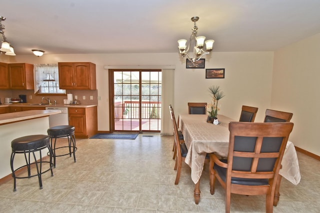dining room with a chandelier and baseboards
