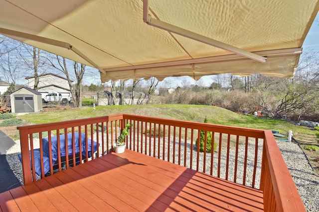 deck featuring a storage unit, an outdoor structure, and a lawn