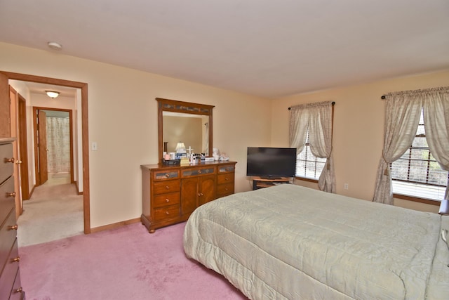 bedroom featuring light carpet and baseboards
