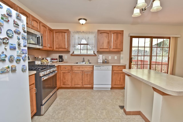 kitchen featuring appliances with stainless steel finishes, light countertops, and a sink