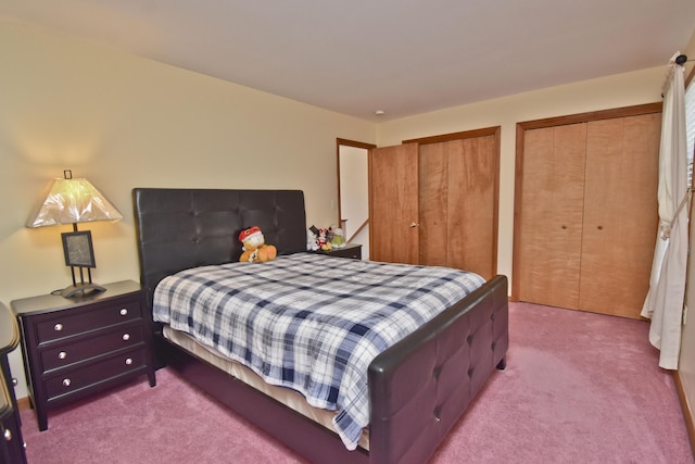 bedroom featuring carpet floors and multiple closets