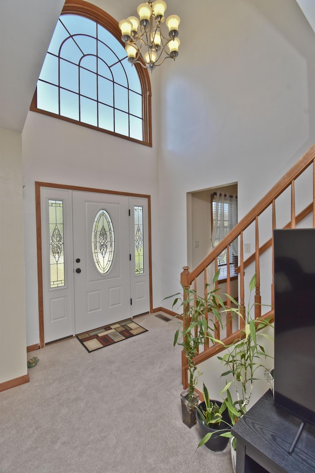 entrance foyer with an inviting chandelier, carpet, stairs, and a high ceiling
