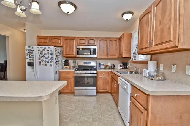 kitchen featuring a sink, appliances with stainless steel finishes, brown cabinetry, and light countertops