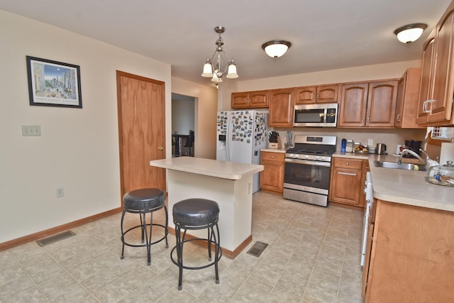 kitchen with visible vents, stainless steel appliances, a kitchen breakfast bar, and light countertops