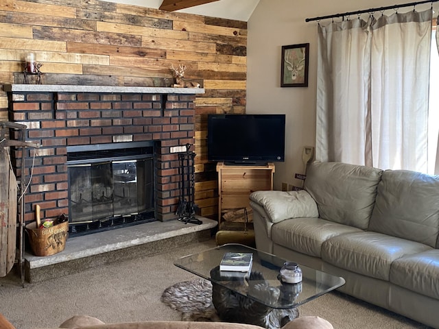 living room with carpet flooring, wood walls, lofted ceiling, and a brick fireplace