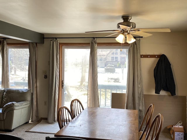 dining space with ceiling fan, light carpet, and plenty of natural light