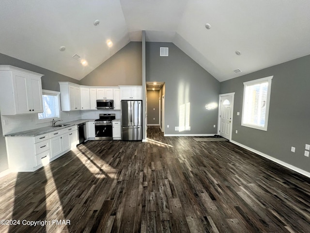 kitchen featuring high vaulted ceiling, visible vents, stainless steel appliances, and dark wood-style flooring