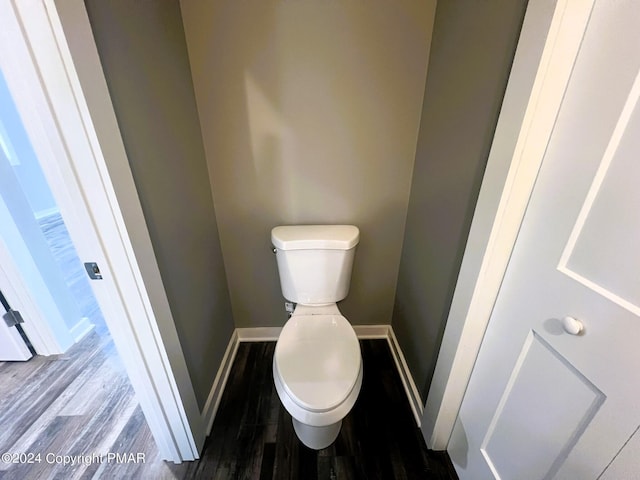 bathroom with wood finished floors, toilet, and baseboards