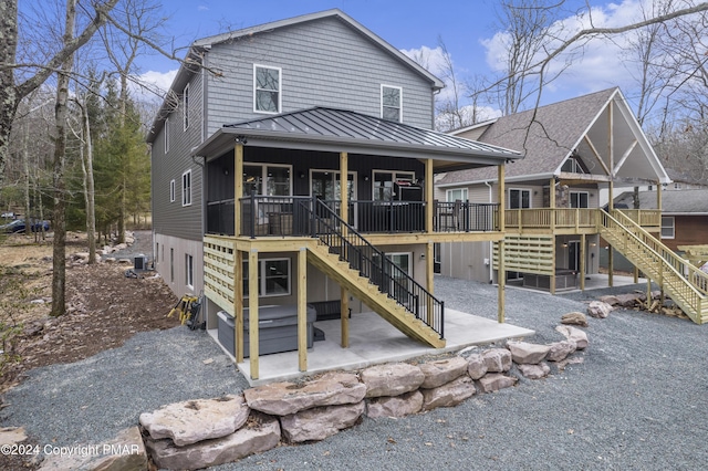 back of house with stairway, metal roof, a standing seam roof, central air condition unit, and a patio area