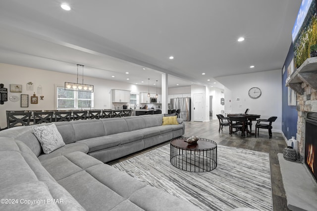 living area featuring baseboards, a fireplace, wood finished floors, and recessed lighting