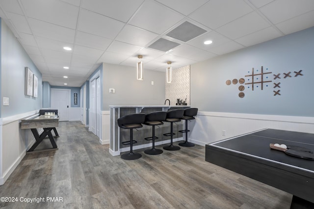 playroom with wainscoting, indoor wet bar, wood finished floors, and visible vents