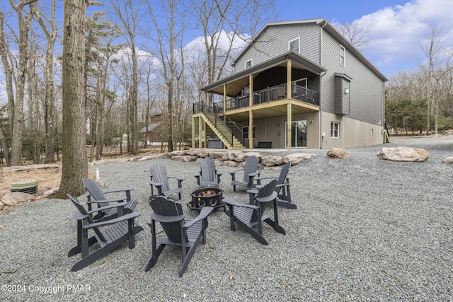 back of property with stairs, an outdoor fire pit, and a deck