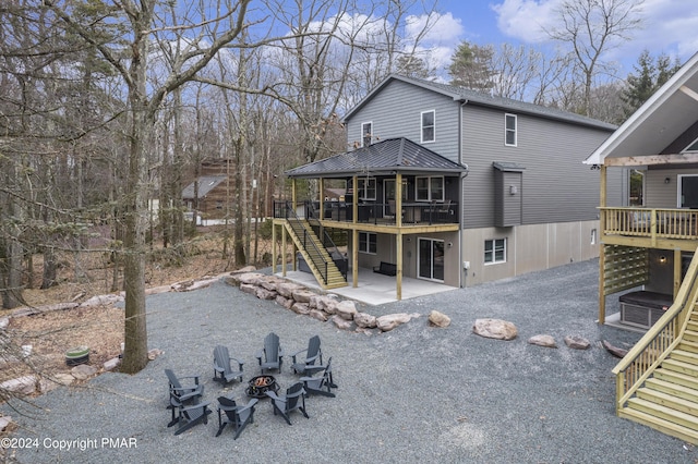 rear view of property with a patio area, stairs, a fire pit, and a wooden deck